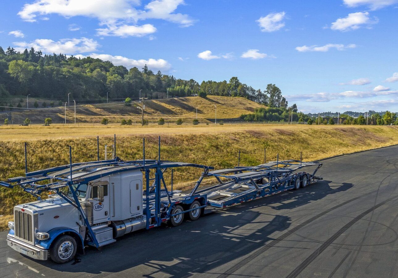 A blue semi truck driving down a road.