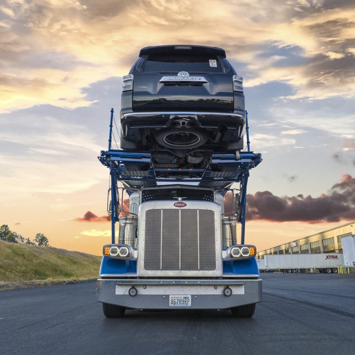 A semi truck with a car on top of it.